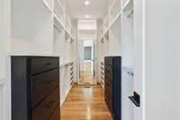Primary bedroom walk in closet with built in cabinetry