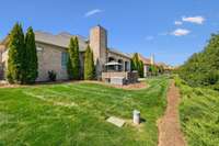 The fenced backyard is beautifully maintained and offers a mix of green space, privacy landscaping, and a spacious patio area—ideal for relaxing, entertaining, or future customization like a pool or garden.
