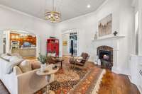 The living room features a gas fireplace with marble surround, soaring ceilings, and custom trim. Open to the kitchen, it creates a warm and elegant space for gathering.