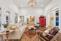The living room flows easily into the kitchen and dining areas, with wide openings and detailed trim that enhance the open feel. Large windows bring in natural light and offer views of the covered patio.