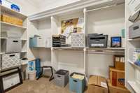 This spacious walk-in closet offers built-in shelving, ample hanging space, and custom organization. It's ideal for clothes, office storage, or both, and features a window for natural light and a functional layout that adapts to your needs.