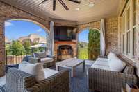 Cozy and stylish, this covered patio features a fireplace, mounted TV, and lounge seating. The perfect space to relax or entertain while enjoying views of the backyard.