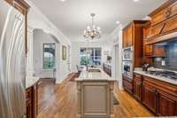 Elegant archways, dual chandeliers, and ample natural light enhance the flow from the kitchen to the breakfast area and living room. This layout blends beauty and function for effortless everyday living and entertaining.