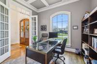 This main-level office features French doors, a large front-facing window, and access to a 3/4 bath and closet, making it ideal for work or flexible guest use.