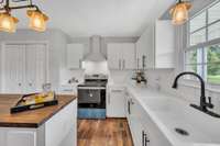 The cabinets, cabinet hardware, quartz countertops, butcher block island countertop, hood vent, farmhouse sink, faucet, lighting, flooring, paint, new faucet and subway tile back splash complete the remodel.