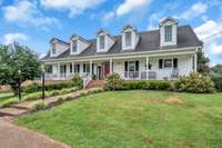 A closer view of this southern beauty.  Five large dormer windows, full length porch, mature landscaping, new lighting and aggregate driveway and sidewalk rounds out the look.
