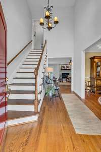 Come inside....A two story entrance foyer with updated lighting, real hardwood floors and fresh paint are just the beginning.  The stair treads are wood and the slight curve of the stairway adds interest.  Lots of wall space to add your own touch.