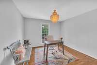 This room is being used as a home office. It has hardwood floors, fresh paint, new lighting & a walk in closet. This room overlooks the front porch/yard.  This is the smaller of the bedrooms so it would be a great nursery or child's room.