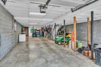 View was taken from the garage door looking towards the house stairs.  Freezer conveys.  Space for your vehicles, mowers, bikes, holiday, etc.  The current seller has holiday totes & a pool table (it conveys) in the additional space.