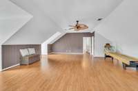 Another view of the bonus room with 3 windows  & a walk-in closet.  There is a separate hvac unit for the 2nd floor and another set of stairs leading down to the kitchen.  There's a skee ball game that the owner will leave.