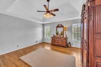 The primary bedroom is on the main floor.  It has a trey ceiling, new lighting, fresh paint, plantation shutters and hardwood floors.  It is sparsely furnished but you can see that it can accommodate a Queen/King bed with no problem.