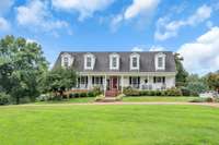 The house sits further from the road than the photo indicates.  It's a custom built Cape Cod that has a very Americana feel.