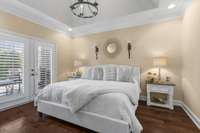 Primary bedroom with King sized bed and French doors leading to back covered patio