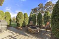 Firepit in the backyard with added trees for privacy