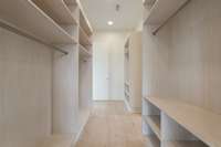 Expansive pass through closet connected both the primary bedroom and bathroom