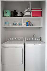 Laundry area, to include washer & dryer with storage shelves.