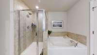 Separate shower and tub in the primary bathroom.
