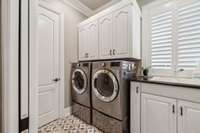 massive laundry room with built in ironing board and ample storage
