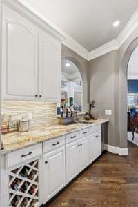 butler hallway with wet bar and plenty of cabinets