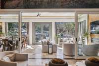 Three season patio with full outdoor kitchen, dining, seating area, media, heated floors, motorized full screens, motorized clear shades!
