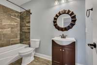 Beautiful 3rd full bathroom, featuring  bath tub and shower combo with tile shower and tiled floor.