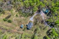 View shows main house surrounded by outbuildings, each with a distinct purpose. Diagonally from pavilion is an open lawn, formerly a soccer pitch. Together, the main house, outbuildings, pavilion, and open space form a functional property layout.