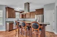 Beautiful large kitchen with granite countertop, SS appliances, island range hood, pantry and lots of cabinets for storage. This is a culinary delight!