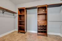 Closet has custom built cabinets and ceramic tile floors.