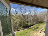 view under covered porch looking at naturn