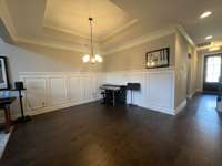 Dining Room with Wainscoating trim and recessed trey ceiling and crown molding; It is large enough for a large dining table or grand piano.
