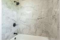 Relax the day away in this tub and shower with tile surround.