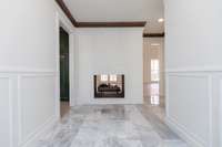 Large Entryway with double sided fireplace and marble tile