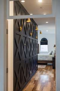 Showcase your cherished art pieces against this chic accent wall, offering a harmonious transition to your private escape.