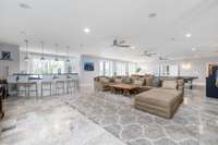 Welcome to the grand, airy downstairs entertainment and recreation room—perfect for hosting large gatherings, relaxing with friends, or accommodating larger entertainment pieces like a ping pong table, pool table, or arcade games.