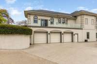 The expansive 3 car garage is pleasantly tucked away on the side of the house. Enter here to access the sprawling lower level without the need to climb any stairs (great for multigenerational living).