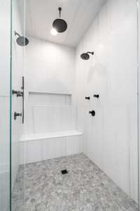 Steps from the soaking tub, the extra large shower features three different showerheads, a bench, and an extra-wide niche—transforming everyday showering into a spa-like experience.