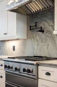 The Thermador gas range and double oven offer top-tier performance, along with a sleek pot filler above the range for added convenience.