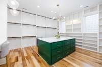 Continue through the bathroom to discover this sparkling hidden gem—a 17ft x 14ft closet fit for a celebrity wardrobe. Sturdy clothing racks, a built-in safe, and a dedicated cosmetic counter are both functional and lavish details.