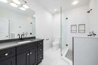 This refreshed lower level bathroom is complete with a sparkling new vanity, toilet, and shower that all leave a dazzling impression.