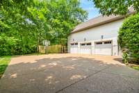 This fully-fenced, private back yard has walkways to create flow and accessibility around the home, along with a basketball half-court near the garage.