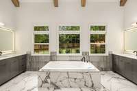 The primary bathroom is a true retreat with a beautiful soaking tub situated under massive windows and skylights.