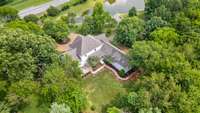 Large estate-style layout with winding driveway and a balance of forested privacy and open lawns. This wooded perimeter serves as a visual and acoustic buffer, adding serenity.