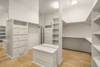 The primary closet is an incredible space with custom wood built-ins and full length mirror.