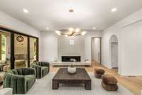 Clean-lined and modern, this open-concept living room features contemporary lighting and sliding glass doors leading to the patio and backyard.