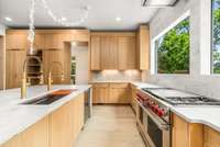 A showcase of symmetry, this kitchen features expansive windows, custom cabinetry, and high-end finishes.
