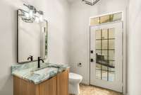 This is the second of two half bathrooms on the main level, and there is an exterior entrance that leads to the outdoor space adjacent to the hot tub.