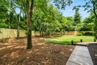 Paved walkways throughout the property, connecting backyard areas, patio, garden, and front entrance.