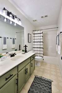 Hall bath. At just under 11ft deep, this bath has extra space for bedroom two and three to share. Excellent storage with a wide vanity and linen coset behind bath door.