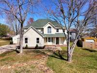 A wide concrete driveway leads to a two car garage with storage shelves and  two windows for natural light. Garage door opener.