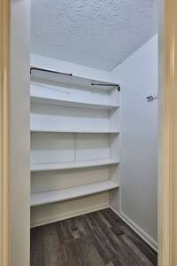 Large pantry is right off kitchen and near garage walk through door for easy grocery drop off. Curtain swing rods for hiding shelves if desired.